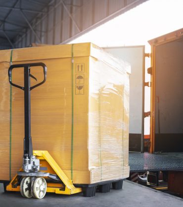 cargo-box-with-hand-pallet-truck-is-loading-into-container-shipment-delivery-warehouse-logistics